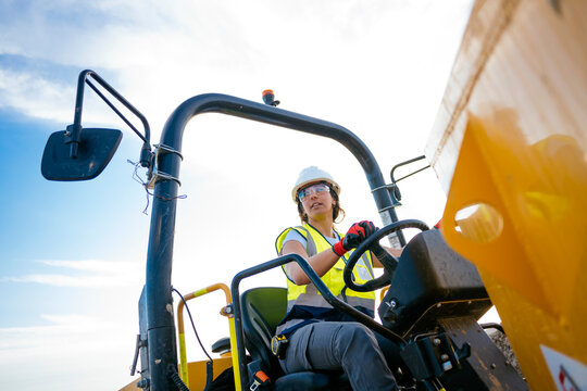 Female construction worker operating heavy machinery outdoors