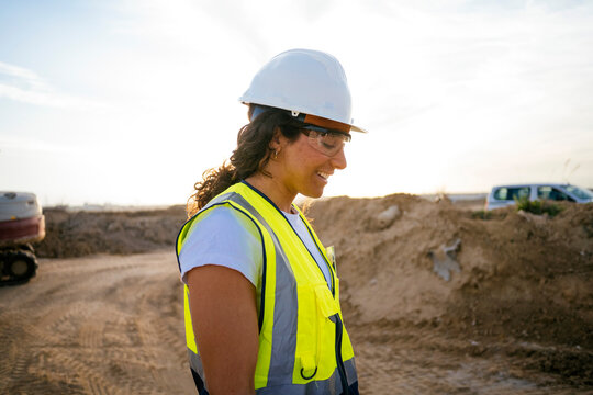 Woman construction worker wearing hard hat at building site