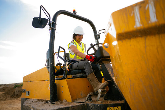 Female construction worker operating heavy machinery onsite