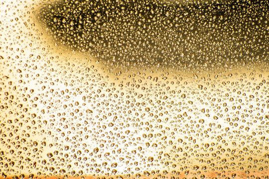 Water droplets on a golden surface creating abstract art