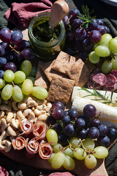 Outdoor picnic platter with grapes, cheese and pesto