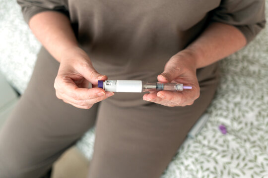 Person holding injection pen for weight loss therapy