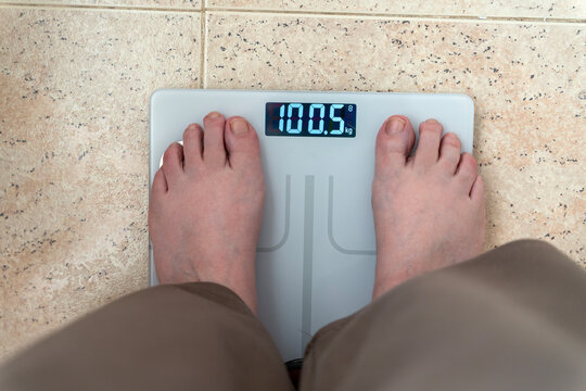 Person standing on a digital scale for weight measurement