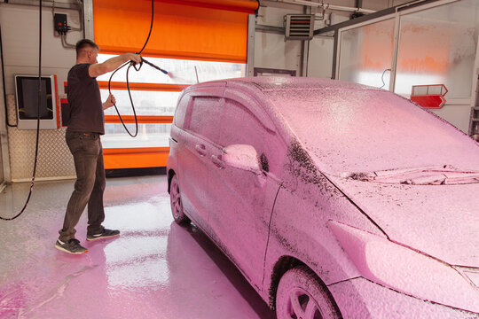 Self-service car wash with pink foam and pressure spray