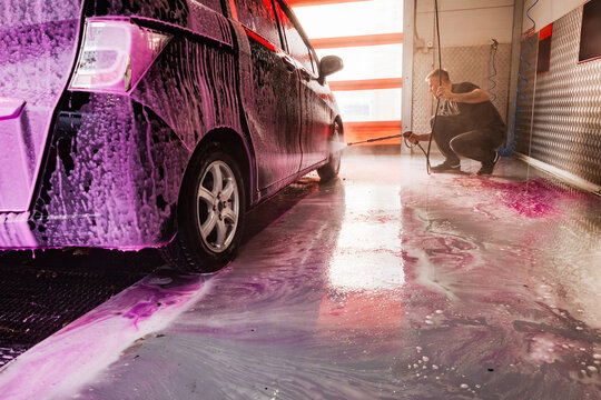 Self-service car wash with purple foam and pressure washer
