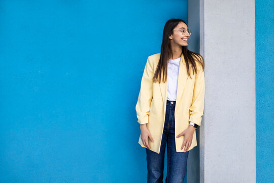Young woman in yellow blazer on colorful blue background