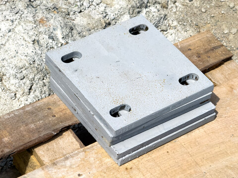 Stacked steel base plates with bolt holes on pallet