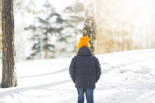 Little boy walking in a snowy spring park