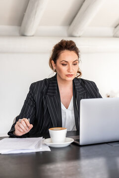 Businesswoman focused on work at office desk with coffee