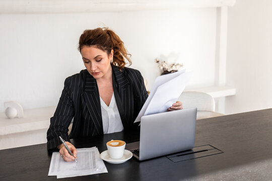 Woman working diligently on documents in office setting