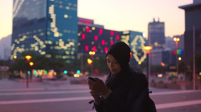 Photography, night or Muslim woman with phone in city, international student or study abroad for post. Bokeh, mobile or happy person with hijab in town, evening picture or exchange programme blog