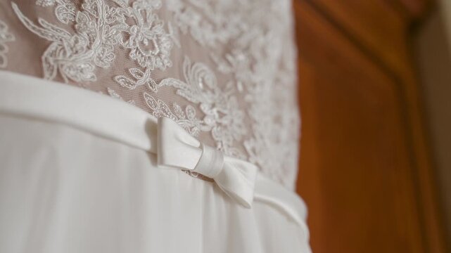 White lace dress with bow hanging indoors