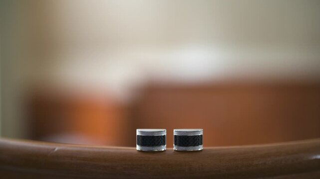 Pair of Small Metal Cylinders on Curved Wooden Surface