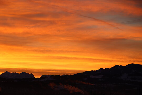 Fiery Orange Sunset Sky Over Silhouetted Mountains