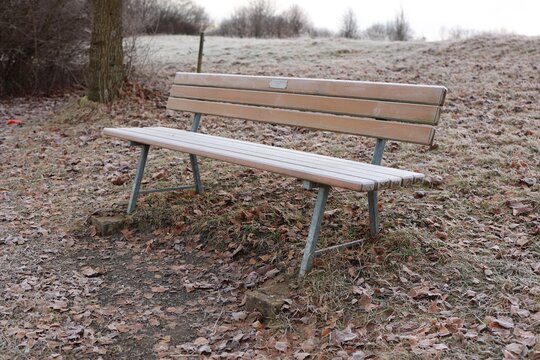 Wooden Bench Covered in Hoar Frost in Winter Field