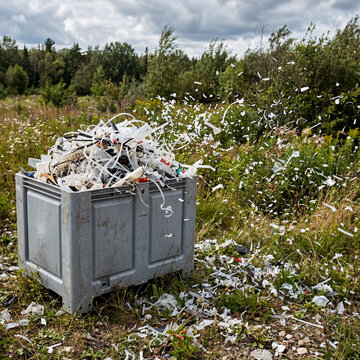 Commercial Waste Plastic Receptacle Overflowing With Manufacturing Offcuts Blown By Intense Outdoor Air Currents Environment