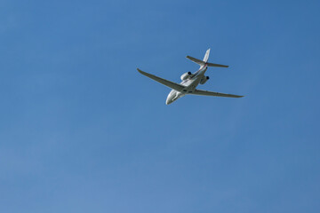 Fototapeta premium Private jet airplane flying high in blue sky over Hostivice