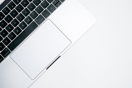 Top view of modern silver laptop keyboard and trackpad isolated on a white background with copy space