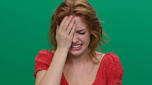 Female facepalming after making a silly mistake on green screen.