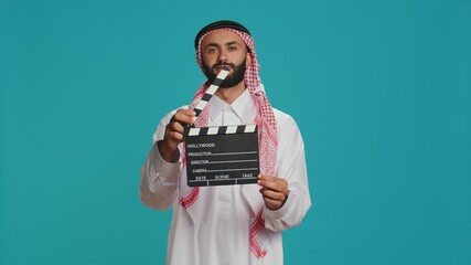 Islamic adult with clapperboard used for action takes on movie making industry, young cinema...