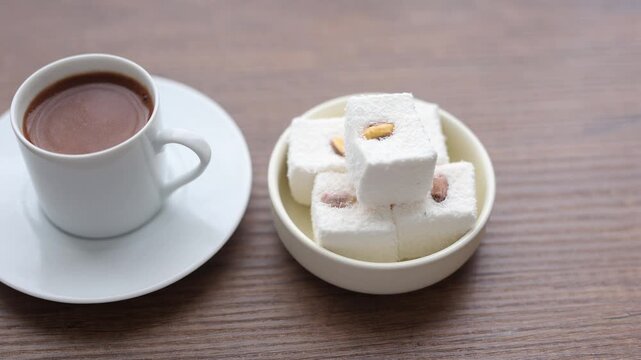 Close-up of traditional Turkish coffee served with delicious Turkish delight lokum on an elegant platter