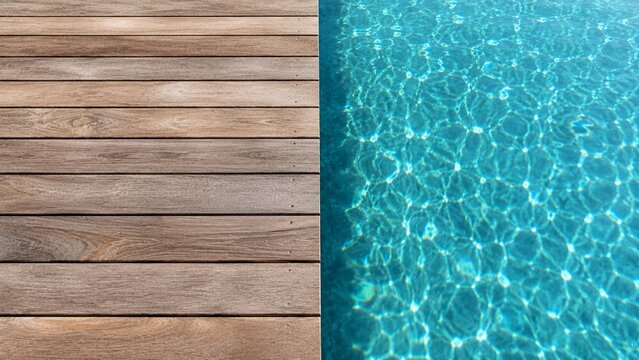 Top-down view of a wooden deck border and clear turquoise swimming pool water