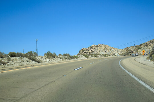 Westbound ascent on Interstate 8 through rugged Imperial County in Southern California desert with open road and clear sky copy space