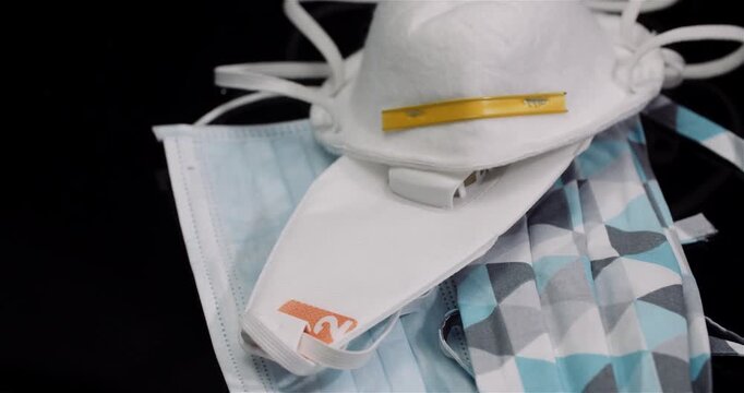 Protective face masks and respirator arranged on dark background