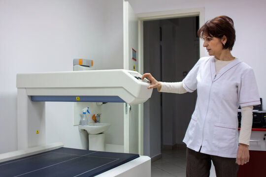 Woman nurse operating  bone densitometry room in medical clinic density scanning machine