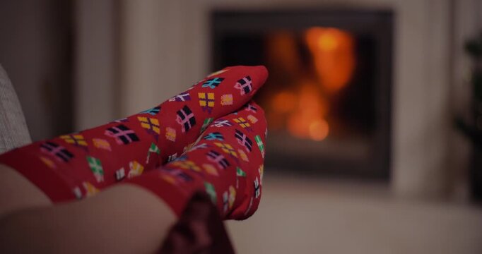 Cozy feet in patterned socks by a glowing fireplace