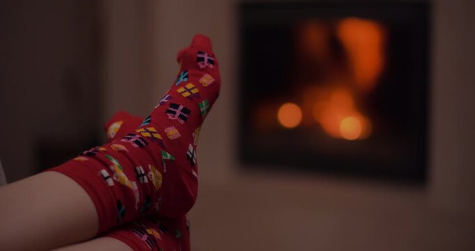 Patterned socks resting near a glowing fireplace