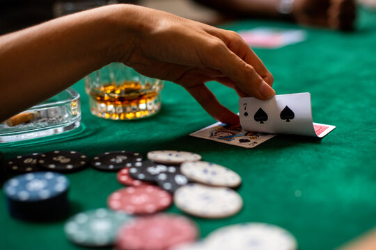 Poker hand with whiskey glass.