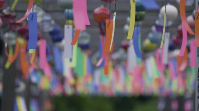 夏の風物詩として、多数の色とりどりの風鈴が揺れる涼しげで華やかな光景
