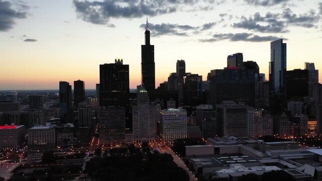 Stunning chicago cityscape at sunset with illuminated buildings and sky over millennium park.