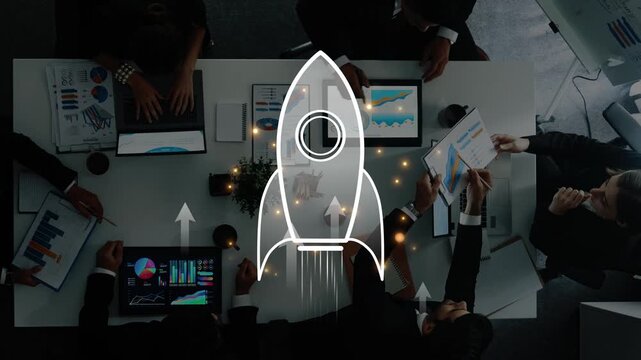 A business team collaborates around a modern office table, analyzing data and strategizing for growth, symbolized by a rocket design that represents innovation. Raster