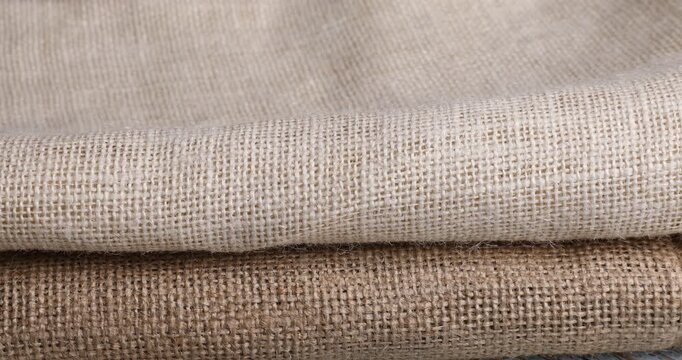 Stacking folded natural burlap fabrics, closeup view