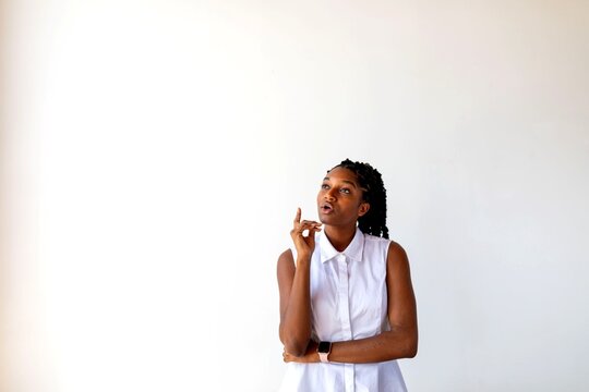Thoughtful woman in white shirt.