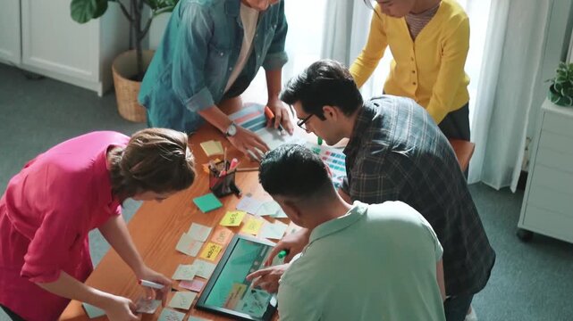 Time lapse of manager writing idea on sticky note and explain idea about web design. Professional marketing team or programmer brainstorming idea while looking at tablet with color palette. Symposium.