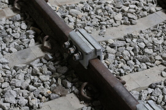 Close-up view of a railway track with ballast and a rail fastening system
