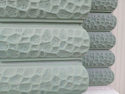 Close-up of a mint green architectural facade with textured rusticated wall plaster patterns. High-quality macro photograph of decorative geometric relief blocks, ideal for building design backdrops, 