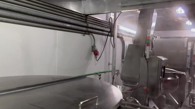 Steam generated from industrial cooking operations rising toward an exhaust hood and forming condensation droplets. Example of moisture management, ventilation systems, and environmental conditions in
