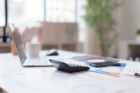 Financial accounting calculator report pen graphs and charts Preparing report.Business reports and pile of documents on gray reflection background.