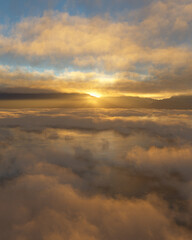 Obraz premium Golden Sunrise Over Misty Water and Distant Mountain Range