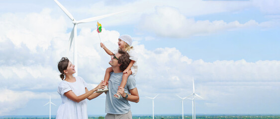 Joyful family embraces outdoor playtime featuring colorful windmill and toy during bright day under partly cloudy sky—perfect for family memories or advertising fresh air activities. © AU USAnakul
