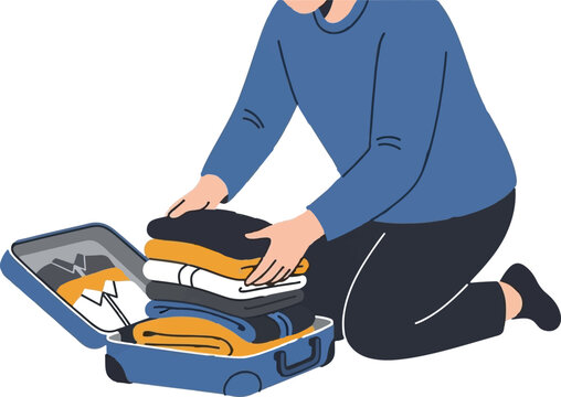 Person carefully packing clothes into open suitcase indoors.