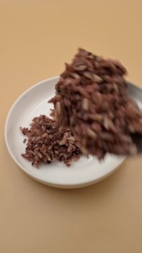 Scooping Khao Riceberry Thai Organic Purple Rice Into White Plate 4K Vertical
