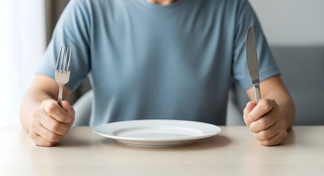Person Waiting Patiently with Empty Plate, Fork and Knife Ready