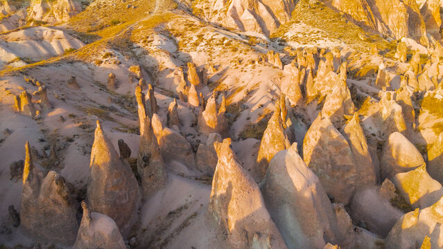 Goreme, Nevsehir, Turkey. Detailed exploration of Devrent Valley revealing intricate erosion details and mineral variations in sunset light.. Aerial View