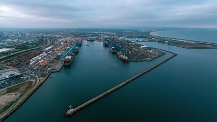 Obraz premium Aerial view of a harbor river and industrial docks at sunset