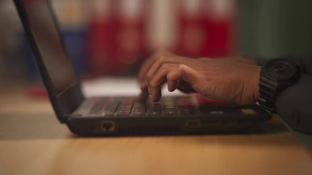 Hands Typing on Laptop Keyboard in Modern Office Workspace